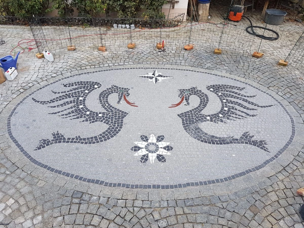 Kunstvolles Natursteinmosaik mit zwei Drachen, Windrose und Stern im Innenhof