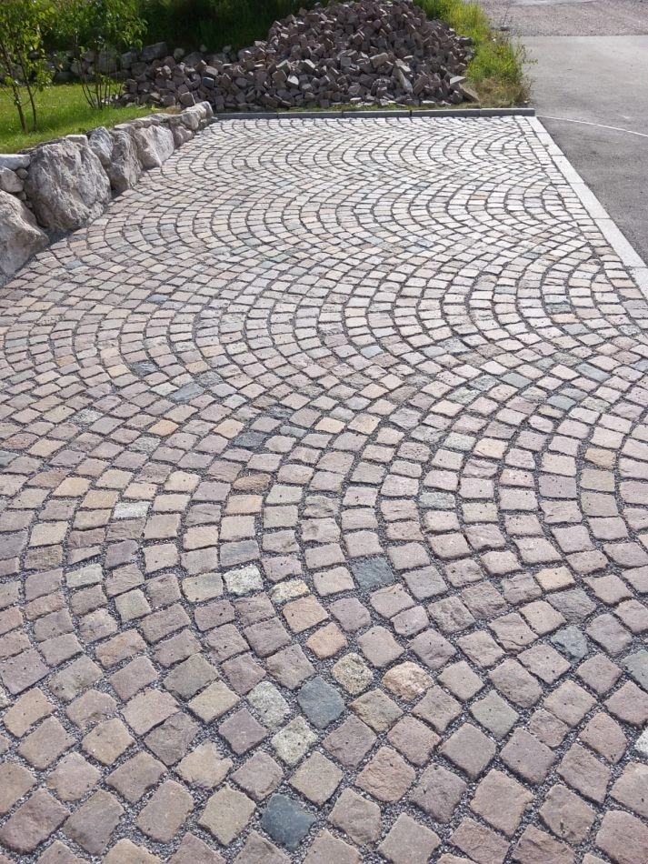 Fächerförmig verlegter Natursteinpflaster-Parkplatz mit Natursteinmauer