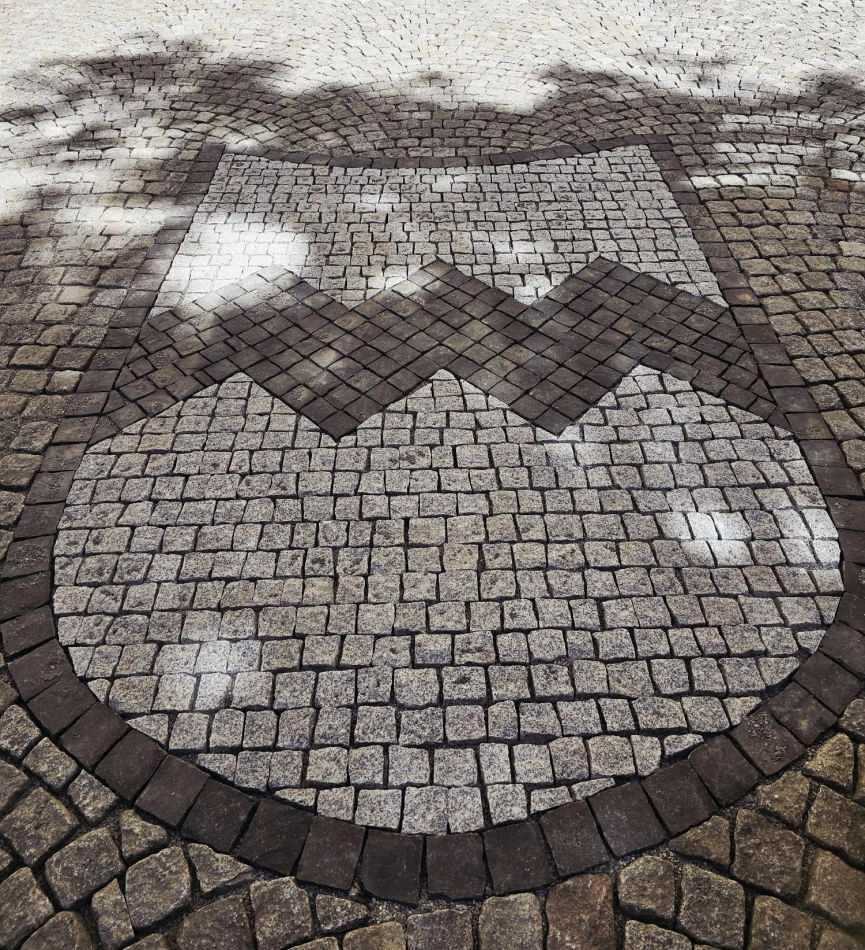 Natursteinmosaik in Wappenform aus hellen und dunklen Pflastersteinen